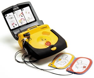 Een AED met de klep open en de elektrodeplakkers ernaast
