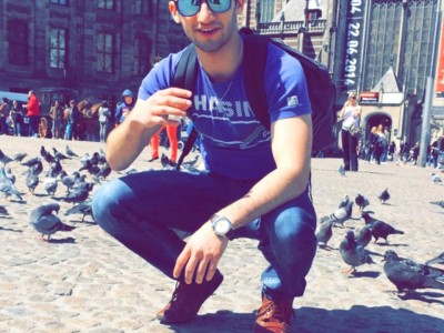 Bashar Razoki hurkend op een plein met duiven